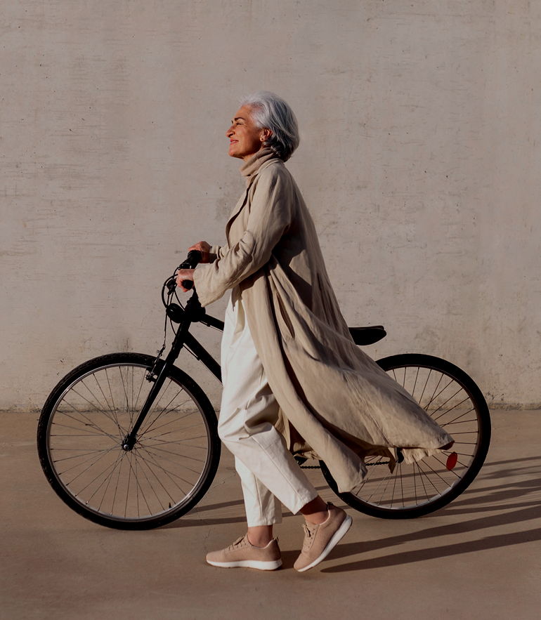 Woman walking next to bike.